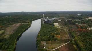 AX152_004 - 5.5K aerial stock footage flying over Merrimack River, approaching a power plant, autumn, Bow, New Hampshire