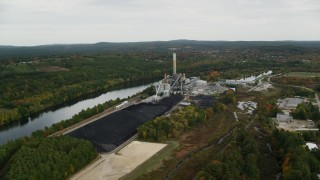 AX152_005 - 5.5K aerial stock footage flying by Merrimack River, approaching a power plant, autumn, Bow, New Hampshire