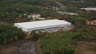 AX152_007 - 5.5K aerial stock footage flying by large warehouse building, colorful foliage, autumn, Bow, New Hampshire