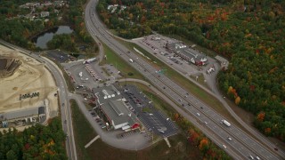 AX152_008E - 5.5K aerial stock footage approaching strip malls, Interstate 93, tilt down, autumn, Bow, New Hampshire