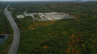 AX152_010 - 5.5K aerial stock footage flying over forest, approaching a quarry, pan right, autumn, Bow, New Hampshire