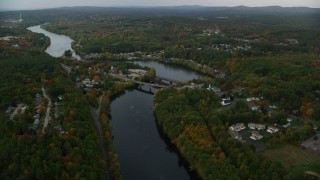 AX152_012 - 5.5K aerial stock footage orbiting small bridges, Merrimack River, small town, autumn, Hooksett, New Hampshire