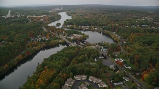AX152_012E - 5.5K aerial stock footage orbiting small bridges, Merrimack River, small town, autumn, Hooksett, New Hampshire