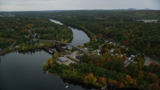 AX152_016 - 5.5K aerial stock footage orbiting small town, small bridges, Merrimack River, autumn, Hooksett, New Hampshire