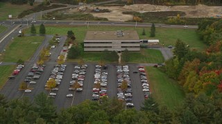 AX152_018 - 5.5K aerial stock footage approaching an office building, tilt down, autumn, Hooksett, New Hampshire