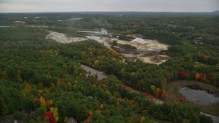 AX152_023 - 5.5K aerial stock footage flying over colorful trees, approaching small quarry, autumn, Hooksett, New Hampshire