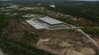 AX152_029 - 5.5K aerial stock footage over quarry, approach warehouse building, autumn, Hooksett, New Hampshire
