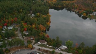 AX152_049 - 5.5K aerial stock footage flying by Crystal Lake, waterfront homes, autumn, Manchester, New Hampshire