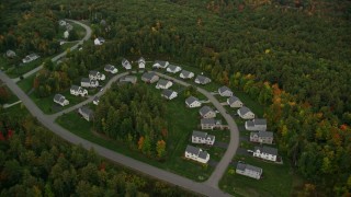AX152_050 - 5.5K aerial stock footage flying by tract homes, colorful trees in autumn, tilt down, Manchester, New Hampshire