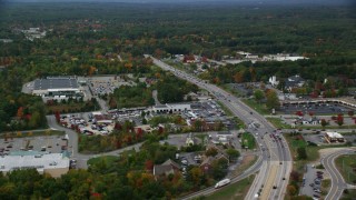 AX152_055 - 5.5K aerial stock footage flying by car dealership, strip mall, Nashua Road, autumn, Londonderry, New Hampshire