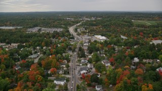 AX152_059E - 5.5K aerial stock footage flying by neighborhoods, Broadway, car auction, autumn, Derry, New Hampshire