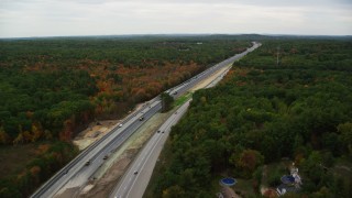 AX152_064 - 5.5K stock footage aerial video flying over Interstate 93 through colorful foliage in autumn, Derry, New Hampshire