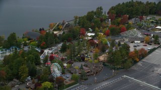 AX152_072 - 5.5K aerial stock footage orbiting Canobie Lake Park, colorful trees in autumn, Salem, New Hampshire