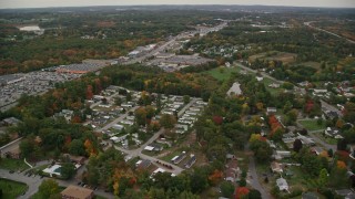 AX152_082 - 5.5K aerial stock footage flying by mobile home park, stores, autumn, Salem, New Hampshire