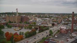 AX152_104E - 5.5K aerial stock footage fly over a bridge over Merrimack River and factories with smokestacks, approach parking gargage, autumn, Lawrence, Massachusetts