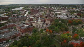 AX152_110E - 5.5K aerial stock footage flying over park with partial fall foliage toward City Hall, autumn, Lawrence, Massachusetts