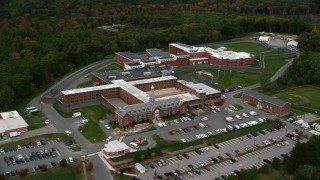 AX152_154 - 5.5K stock footage aerial video orbiting away from a prison among trees, autumn, Billerica, Massachusetts