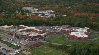 AX152_158E - 5.5K aerial stock footage flying around a prison backed by fall foliage, Billerica, Massachusetts