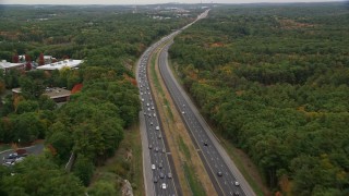 AX152_162E - 5.5K aerial stock footage following a highway bordered by fall foliage toward an overpass, Billerica, Massachusetts