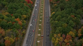 AX152_164 - 5.5K stock footage aerial video following a highway surrounded by fall foliage, Bedford, Massachusetts