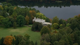 AX152_187 - 5.5K aerial stock footage flying by mansion near the lake, autumn, Wellesley, Massachusetts