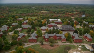 AX152_198E - 5.5K aerial stock footage flying by water tower and Medfield State Hospital among fall foliage, Medfield, Massachusetts