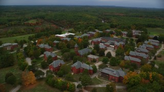 AX152_200 - 5.5K stock footage aerial video orbiting Medfield State Hospital nestled among partial fall foliage, Medfield, Massachusetts