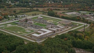 AX152_213 - 5.5K aerial stock footage flying high over Massachusetts Correctional Institution at Norfolk, with autumn trees, Massachusetts