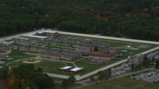 AX152_227 - 5.5K stock footage aerial video of a side view of Massachusetts Correctional Institution at Norfolk among fall foliage, Massachusetts