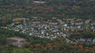 AX152_229 - 5.5K aerial stock footage of suburban homes among fall foliage, Walpole, Massachusetts