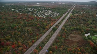 AX152_233E - 5.5K aerial stock footage of an Interstate near neighborhood nestled among fall foliage, Canton, Massachusetts