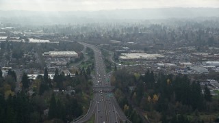 AX153_004 - 5.5K aerial stock footage of Highway 217 and shopping centers in autumn with clouds, Beaverton, Oregon