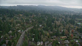AX153_006E - 5.5K aerial stock footage flying over trees and residential area on a cloudy day, autumn, Portland, Oregon