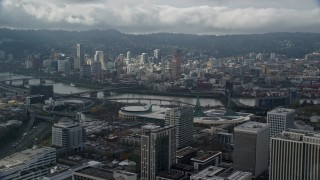 AX153_023E - 5.5K aerial stock footage flying over office buildings and high-rises with view of Downtown Portland with clouds, Oregon