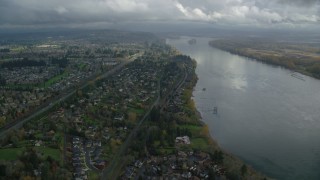 AX153_141 - 5.5K aerial stock footage flying over suburban riverfront houses by Highway 14 in Vancouver, Washington
