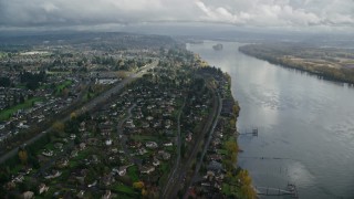 AX153_141E - 5.5K aerial stock footage flying over suburban riverfront houses by Highway 14 in Vancouver, Washington