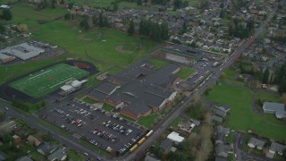 AX153_167 - 5.5K stock footage aerial video orbiting Washougal High School and the football field in Washougal, Washington