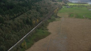 AX153_179 - 5.5K aerial stock footage of a bird's eye view of a train traveling past open fields in Washougal, Washington