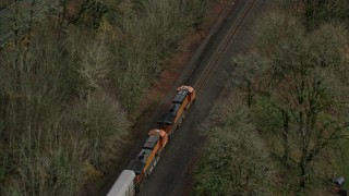 AX153_180E - 5.5K aerial stock footage of a bird's eye tracking a train traveling into Columbia River Gorge, Oregon