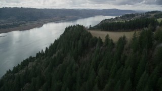 AX153_188 - 5.5K aerial stock footage flying over cliff top trees in Columbia River Gorge, Oregon