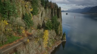 AX154_004E - 5.5K aerial stock footage approaching train tracks and tunnel in the Columbia River Gorge, Oregon
