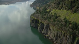 AX154_012 - 5.5K aerial stock footage revealing train tracks emerging from the cliffs of Columbia River Gorge, Washington