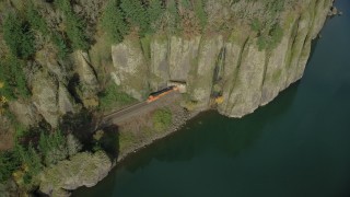 AX154_013 - 5.5K aerial stock footage tracking a train as it leaves Cape Horn Railroad Tunnel in Columbia River Gorge, Washington