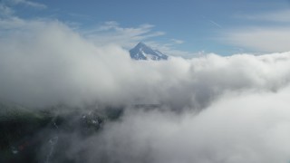 AX154_060 - 5.5K stock footage aerial video approaching Mount Hood, visible above a layer of thick clouds, Cascade Range, Oregon