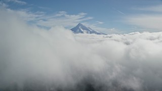 AX154_060E - 5.5K aerial stock footage approaching Mount Hood, visible above a layer of thick clouds, Cascade Range, Oregon