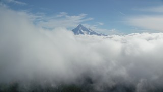 AX154_061 - 5.5K aerial stock footage flying over thick clouds toward the summit of Mount Hood, Cascade Range, Oregon