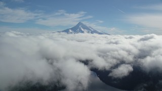 AX154_063 - 5.5K stock footage aerial video flying above clouds to approach snowy Mount Hood, Cascade Range, Oregon