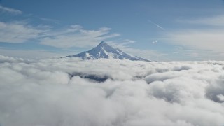 AX154_065 - 5.5K stock footage aerial video of the snowy summit of Mount Hood above the clouds, Cascade Range, Oregon