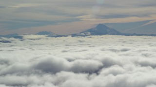 AX154_098 - 5.5K stock footage aerial video of Mount Jefferson and the Three Sisters Volcanoes seen from across low clouds, Cascade Range, Oregon
