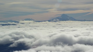 AX154_099 - 5.5K stock footage aerial video of Mount Jefferson and Three Sisters Volcanoes, seen above the clouds, Cascade Range, Oregon